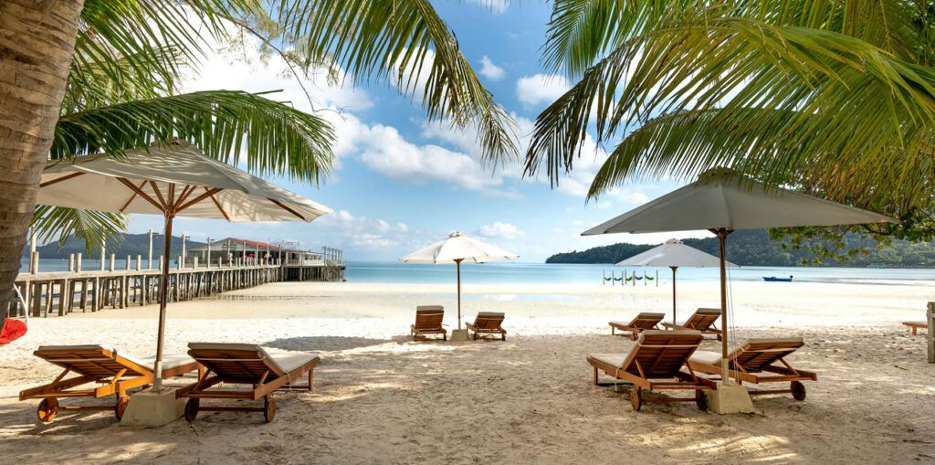 Sunbeds and pier on a Phuket beach — remote work with island lifestyle in Thailand